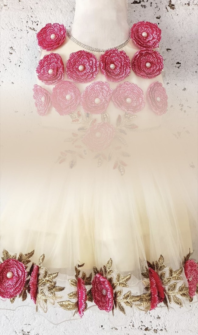 Close-up of hand-finished floral embroidery on a Faraak girls' frock